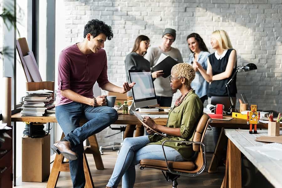 Creative agency team collaborating in a studio, reviewing client work and project margin